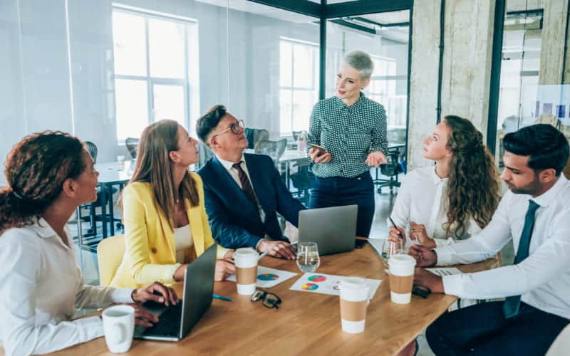 Café no Trabalho. 2 Colaboradores à mesa tomando café no trabalho.