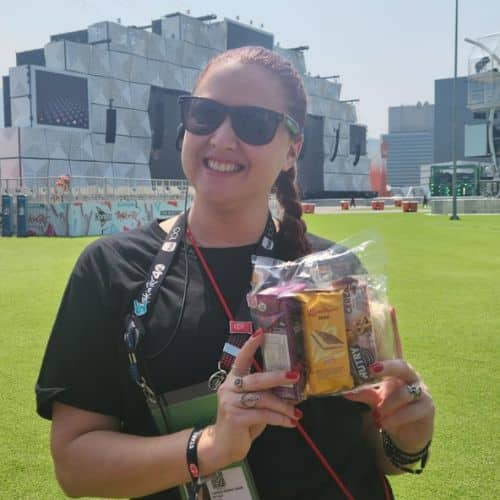 Mulher segurando um kit lanche de coffee break simples num evento