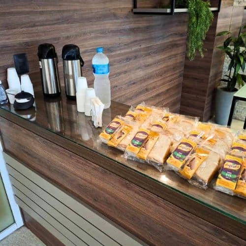 Kit lanche corporativo substituindo coffee break tradicional em bancada de empresa no Rio de Janeiro.